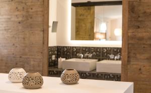 three vases sitting on a table in front of a bathroom at Hotel Les Chambres de Mila Bonifacio in Bonifacio