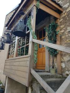 una entrada a una casa con puerta de madera en La Pensine du célèbre sorcier en Bourogne