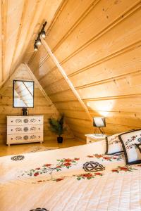 a bedroom with a bed in a wooden ceiling at Apartamenty Harenda Ski in Zakopane