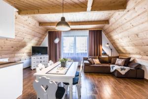 a living room with a couch and a table at Apartamenty Harenda Ski in Zakopane