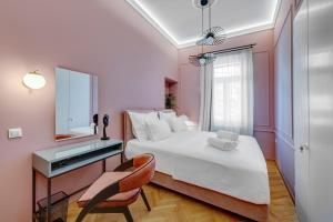 a bedroom with a bed and a mirror and a chair at Amare Boutique Suites in Ermoupoli