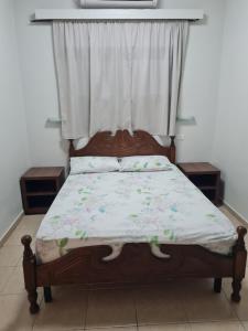 a bed with a wooden frame and a window at Arava Hostel in Eilat