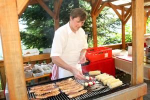a man is cooking food on a grill at Gasthof Käferhube in Murau