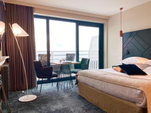 ヴィムルーにあるホテル アトランティックのベッド、テーブル、椅子が備わるホテルルームです。