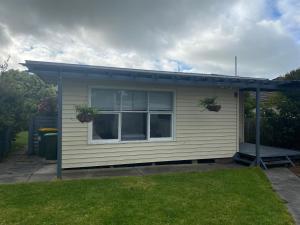 a small house with two potted plants on it at Growse House Yarram 3BR in Yarram