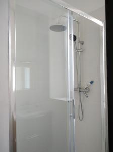 eine Dusche mit Glastür im Bad in der Unterkunft T2 - 2 à 3 personnes - draps et serviettes en option in Lorette