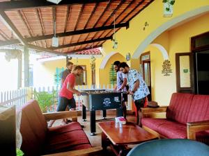 grupa ludzi grających w ping ponga w salonie w obiekcie Carina Beach Resort - 10mins walk to Benaulim Beach w mieście Benaulim