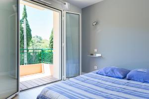 a bedroom with a bed and a sliding glass door at Résidence La Source in Toulon