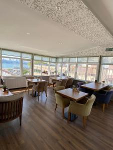 un restaurant avec des tables, des chaises et des fenêtres dans l'établissement ÜSKÜDAR OTEL, à Istanbul