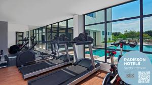 a gym with treadmills and a swimming pool at Park Inn by Radisson Putrajaya in Putrajaya