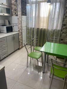 a kitchen with a green table and chairs at Appartment Tashkent in Tashkent +5 photos