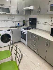 a kitchen with a stove and a washing machine at Appartment Tashkent in Tashkent
