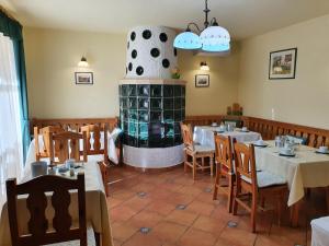 a restaurant with tables and chairs and a fireplace at Bozi Rozi Panzió in Fertőboz