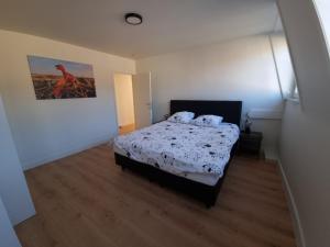 a bedroom with a bed and a painting on the wall at Maison Florimond in Nieuwpoort