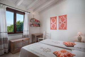 biała sypialnia z 2 łóżkami i oknem w obiekcie Punta Falcone Resort w mieście Santa Teresa Gallura +37 zdjęć