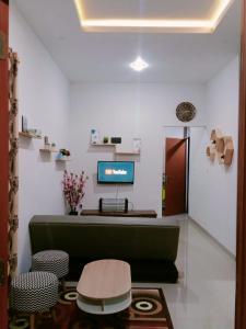 a living room with a green couch and a tv at Villa Lembang Syariah near park & Zoo in Lembang