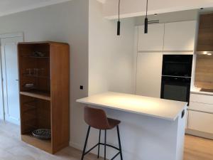 cocina con encimera blanca y taburete en ROS'a tourist & business appartment en Dendermonde