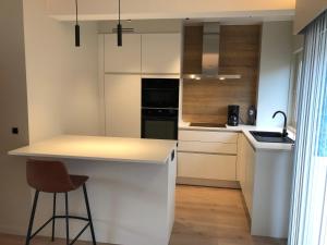 cocina con armarios blancos y encimera en ROS'a tourist & business appartment en Dendermonde