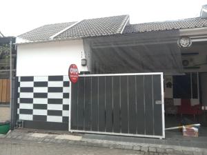 a garage with a gate and a stop sign at OYO 90684 Happy Homestay Syariah in Malang