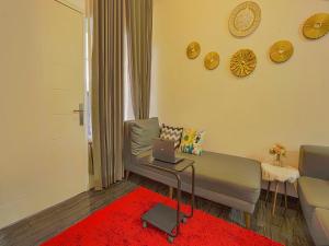 a living room with a couch and a laptop on a table at Hotel O Happy Homestay Syariah in Malang