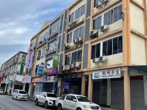 a city street with cars parked in front of buildings at Loft Pals Urbanstay Lodge, Kapit in Kapit