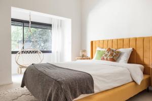ein Schlafzimmer mit einem großen Bett mit einer Schaukel in der Unterkunft RENOVATED LARGE 3RM APARTMENT 5 MIN FROM THE BEACH in Tel Aviv