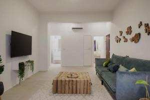 a living room with a green couch and a coffee table at RENOVATED LARGE 3RM APARTMENT 5 MIN FROM THE BEACH in Tel Aviv
