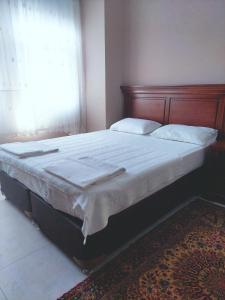 a bed with a wooden headboard in a bedroom at Eser Apart Dalyan in Ortaca