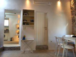 - une cuisine et une salle à manger avec une table et des chaises dans l'établissement Tristrato, à Parikia