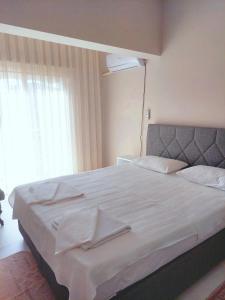 a bedroom with a large bed with white sheets and a window at Eser Apart Dalyan in Ortaca