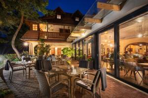 a patio with tables and chairs and a restaurant at Hotel Frýdl in Prague