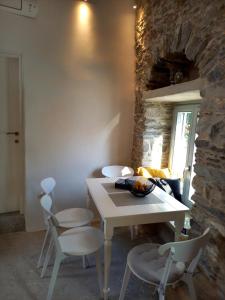 - une table et des chaises dans une pièce dotée d'un mur en pierre dans l'établissement Tristrato, à Parikia