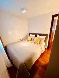 a bedroom with a large white bed with yellow pillows at Suite300 by Palazzina300 in Treviso