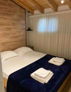 - une chambre avec un lit et 2 serviettes dans l'établissement Lovely Loft 1-Bedroom in the heart of Tirana, à Tirana