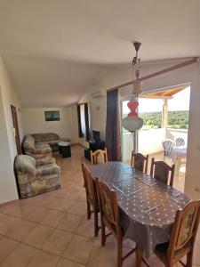 ein Esszimmer und ein Wohnzimmer mit Tisch und Stühlen in der Unterkunft Villa Dorina in Štinjan