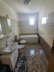 ein Badezimmer mit Badewanne, Toilette und Waschbecken in der Unterkunft Villa Dorina in Štinjan