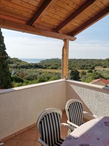 eine Terrasse mit zwei Stühlen und einem Tisch auf einem Balkon in der Unterkunft Villa Dorina in Štinjan