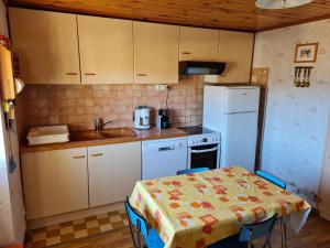 a kitchen with a table and a sink and a refrigerator at Maison à Font-Romeu - Odeillo in Odeillo-Via