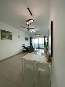 a white dining room with a white table and chairs at Bangi Almyra Suite in Bangi