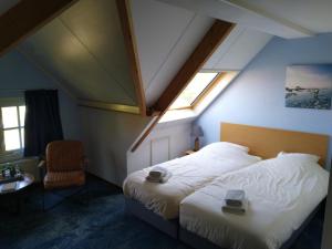 - une chambre avec un lit, une fenêtre et une chaise dans l'établissement De Stormvogel, à Baaiduinen