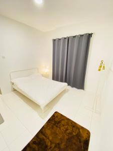 een witte kamer met een bed en een raam bij The Quintet Condominiums 3A-1 in Cameron Highlands