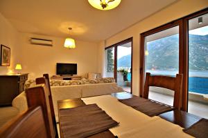 Apartment MiraMare في كوتور: غرفة معيشة مع أريكة وطاولة مع كراسي
