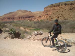 a man riding a bike in the desert at Citadelle Gorges in Aït Ben Ali