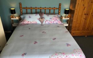 a bed with a heart pillow and flowers on it at Citrus Grove in Nelson