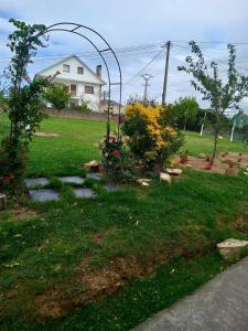 einen Garten mit einem Bogen in der Mitte eines Gartens in der Unterkunft Casa Campanita in Ribadeo