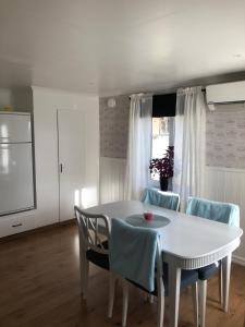 Ein weißer Tisch und Stühle in einem Raum mit einem Tisch und einem Fenster in der Unterkunft Trevlig stuga nära Hovfjället in Torsby