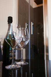 dois copos de vinho sentados numa mesa ao lado de uma garrafa de vinho em B&B Casa Dorotei em Cusighe