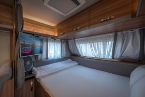 a small room with a bed and a tv in it at Park Timna in Eilat