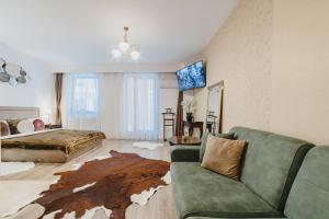 a living room with a green couch and a bed at Seasons Atmosphere Studio in Braşov