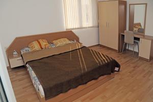 a bedroom with a large bed and a desk at Kirovi Apartments in Primorsko